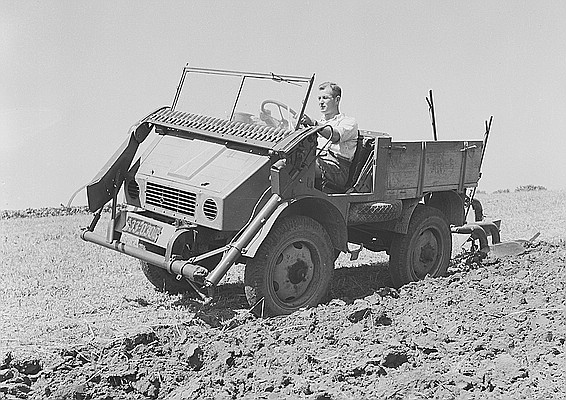 Unimog Prototyp U 1 mit Frontmähwerk, dieses wird in Transportstellung unterhalb der Frontscheibe abgelegt, heckseitig ist ein Pflug angebaut